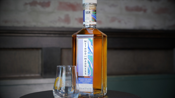 Bottle of whiskey with a glass on a table against a blurred background