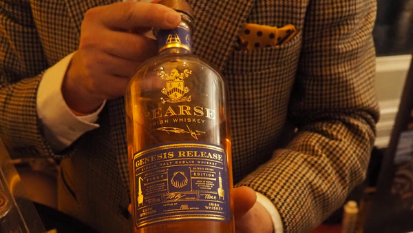 Person holding a bottle of Pearse Irish Whiskey with a blurred background