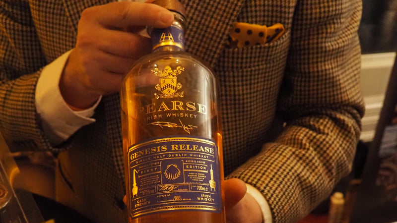 Person holding a bottle of Pearse Irish Whiskey with a blurred background